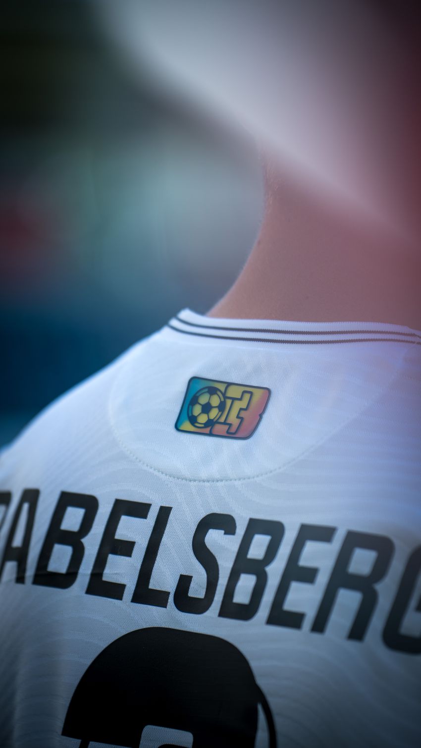 Detailfoto des Nackenbereichs. Dort zu sehen ist das alte Babelsberg 03-Wappen. Es schimmert in Regenbogenfarben.